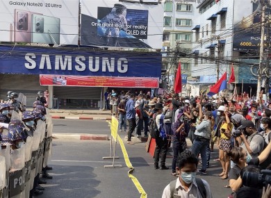 Riot police block the road to prevent protesters from marching forward in capital Yangon