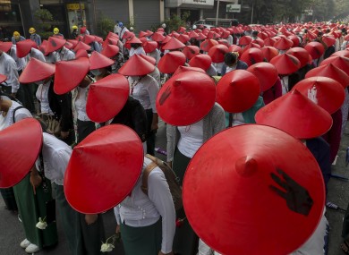 Anti-coup school teachers in their uniform and traditional Myanmar-hats participate in a demonstration in Mandalay, Myanmar