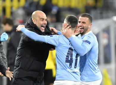 Manchester City manager Pep Guardiola celebrates with goal scorer Phil Foden and Kyle Walker (right).