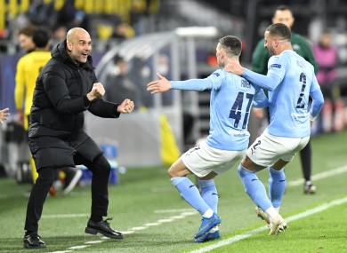 Manchester City manager Pep Guardiola celebrates with goal scorer Phil Foden.
