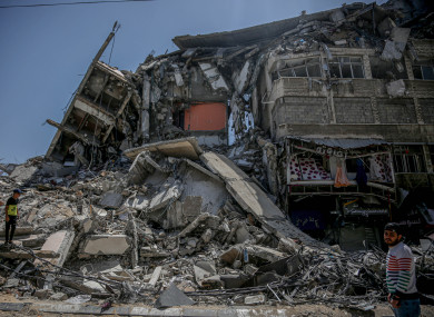 A Palestinian walks past the rubble piled up in Gaza, following the ceasefire agreement.