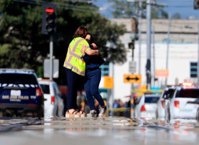 Two people hug on Younger Avenue outside the scene of a shooting in San José.