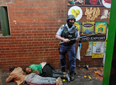 A police officer detains rioters in Johannesburg, South Africa.