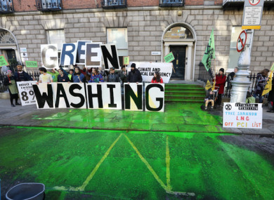 A man sprays the road with green paint as part of a Extinction Rebellion protest over climate change at Fine Gael HQ in Dublin in February 2020.
