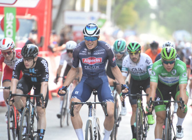 Jasper Philipsen celebrates crossing the finish line.
