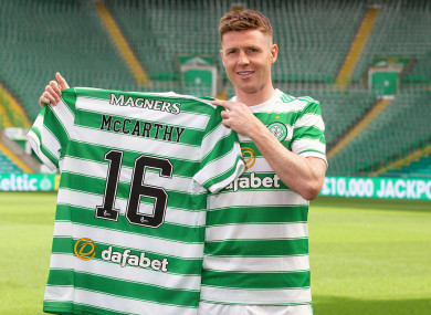 James McCarthy holding up the Hoops shirt with his name and number on the back.