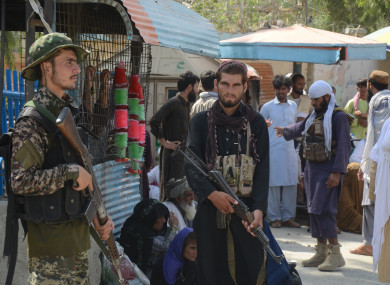 Taliban fighters stand guard on their side at a border crossing point between Pakistan and Afghanistan.