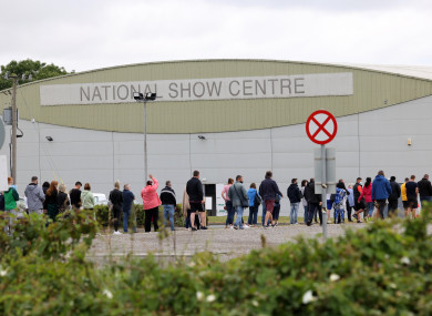 People queue outside a walk-in vaccination centre at the National Show Centre in Swords, Dublin this morning.