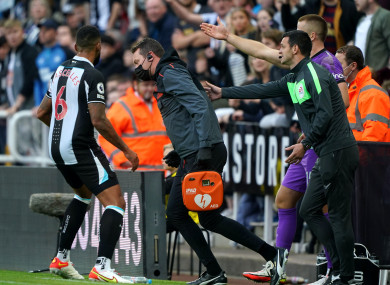 Newcastle United club doctor Paul Catterson (centre) is told by Tottenham Hotspur's Eric Dier and Newcastle United's Jamaal Lascelles (left) to assist a member of the crowd.