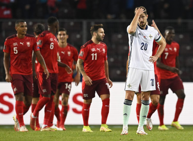 Switzerland's Steven Zuber celebrates scoring their side's first goal of the game with team-mates as Northern Ireland's Craig Cathcart stands dejected.