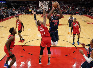 Joel Embiid (21) shoots as Houston Rockets center Daniel Theis (27) defends.