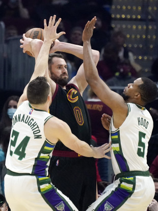 Cleveland Cavaliers' Kevin Love, centre, passes as Milwaukee Bucks' Pat Connaughton, left, and Rodney Hood defend.