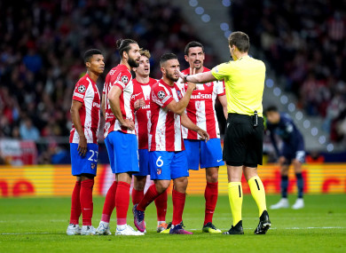 Atletico Madrid players appeal to referee Daniel Siebert.