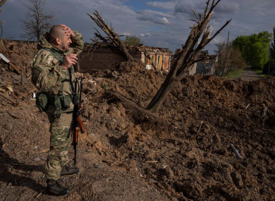 A Ukrainian serviceman inspects a site after an airstrike by Russian forces in Bakhmut, Ukraine