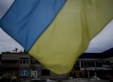 Men work at repairing a building damaged by shelling on the outskirts of Kyiv.
